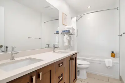 a white bathroom with a sink and a toilet at 4BR Unit In The Heart Of Harrison in Harrison Hot Springs