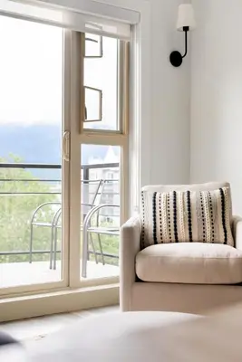 a living room with a chair and a window at 4BR Unit In The Heart Of Harrison in Harrison Hot Springs