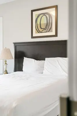 a bedroom with a white bed with a black headboard at Serenity Luxe 2BR unit in Harrison in Harrison Hot Springs
