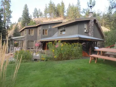 a house with a yard with a bench in front of it at Mountain Springs Nature Retreat in Kaleden