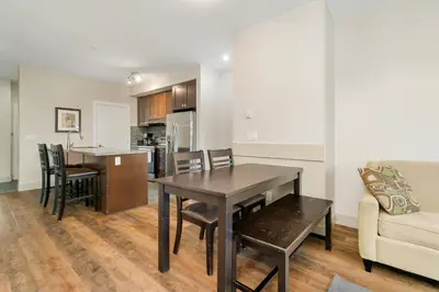 a kitchen and living room with a table and a couch at Chic Haven Stylish 3Bedroom in Harrison Hot Springs