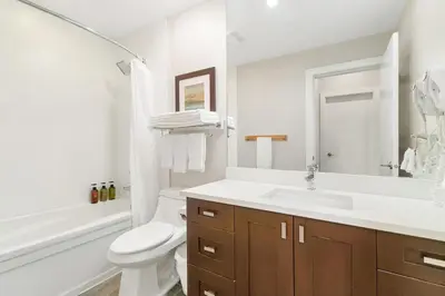 a white bathroom with a sink and a toilet at Chic Haven Stylish 3Bedroom in Harrison Hot Springs