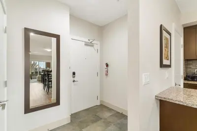 a kitchen with white walls and a mirror on the wall at Chic Haven Stylish 3Bedroom in Harrison Hot Springs