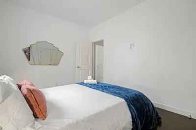 a bedroom with a white bed with a blue blanket on it at Charming 3 Bedrooms Home with BBQ- Deck- Fenced yard-Near WEM & River Valley in Edmonton