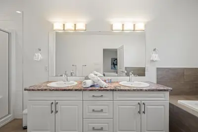 a bathroom with two sinks and a large mirror at Charming 3 Bedrooms Home with BBQ- Deck- Fenced yard-Near WEM & River Valley in Edmonton