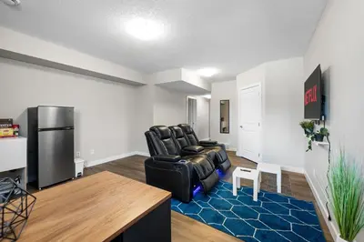 a living room with a black chair and a refrigerator at 1 bedroom in Edmonton