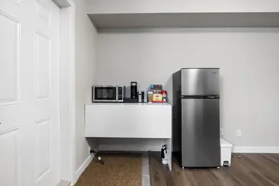 a kitchen with a refrigerator and a counter with a microwave at 1 bedroom in Edmonton