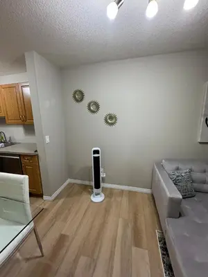 an empty living room with a couch and a kitchen at The Bloom Haven in Edmonton