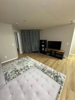 an empty living room with a couch and a television at The Bloom Haven in Edmonton