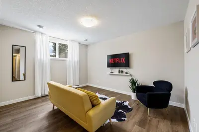 a living room with a yellow couch and two chairs at 2-bedroom in Edmonton