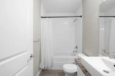 a white bathroom with a toilet and a sink at 2-bedroom in Edmonton