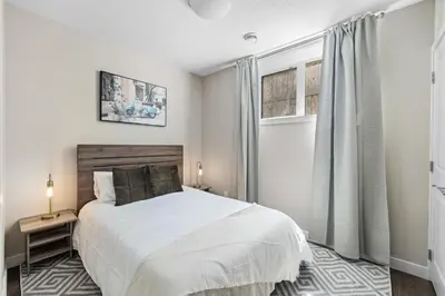a bedroom with a white bed and a window at 2-bedroom in Edmonton