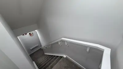 a staircase in a white room with a refrigerator at Cozy & Quiet Calgary 2BR Suite in Calgary
