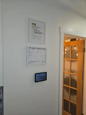 a white wall with a cabinet and a sign on it at A Little R and R Private Sauna Cold and Hot Plunge in Calgary