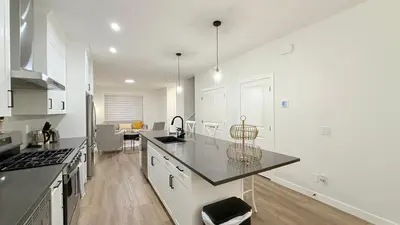 a kitchen with white cabinets and a black counter top at Casa Koko in Calgary