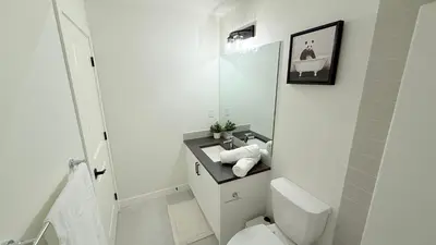 a white bathroom with a toilet and a sink at Casa Koko in Calgary