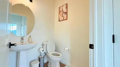 a bathroom with a toilet and a sink and a mirror at La Maison de Koko in Calgary