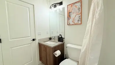 a bathroom with a toilet and a sink and a mirror at La Maison de Koko in Calgary