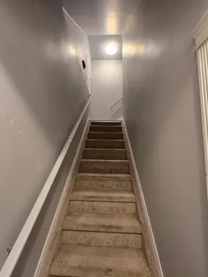 a hallway with stairs with a light on the wall at Basement Suite Private Entry Fort McMurray in Fort McMurray