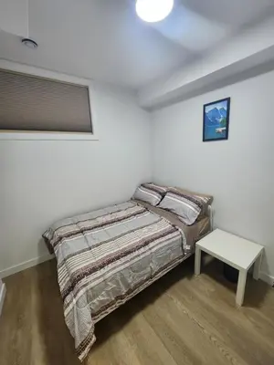 a small bedroom with a bed and a table at Home in Calgary in Calgary