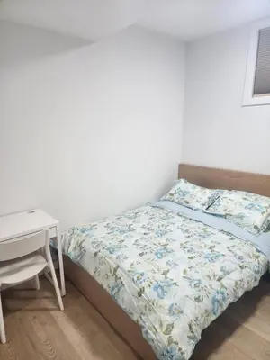 a small bedroom with a bed and a desk at Home in Calgary in Calgary