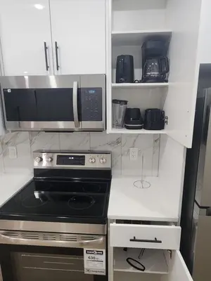 a kitchen with a stove and a microwave at Home in Calgary in Calgary
