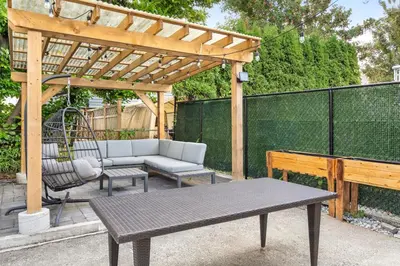 a wooden pergola with a couch and a swing at Callister BNB in Vancouver