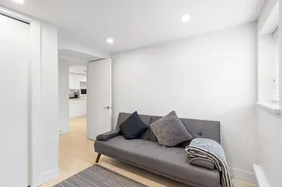 a living room with a gray couch in a white room at Callister BNB in Vancouver
