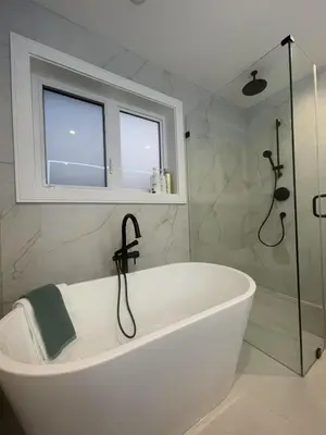 a white bath tub in a bathroom with a window at 3 bed duplex in Kitsilano 10 min to airport and 10 min to downtown in Vancouver