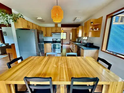 a kitchen with a wooden table and chairs at Eagles Nest - epic blufftop cabin Squamish in Upper Squamish