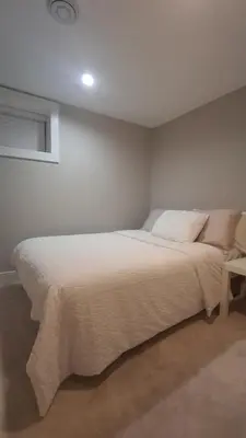 a bedroom with a large white bed with a window at Vancouver Comfort Home 10 min to YVR airport, Close to Downtown in Vancouver
