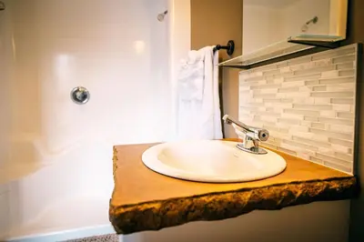a bathroom with a white sink on a counter at Elowen Suites Downtown in Drumheller