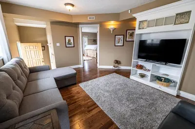 a living room with a couch and a flat screen tv at Elowen Suites Downtown in Drumheller
