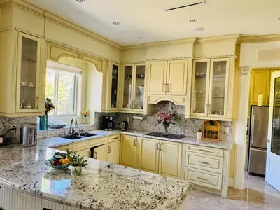 a kitchen with yellow cabinets and granite counter tops at Vancouver Richmond Villa 40 in Richmond