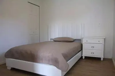 a small bedroom with a bed and a dresser at Downtown one bedroom apartment 2 in Victoria