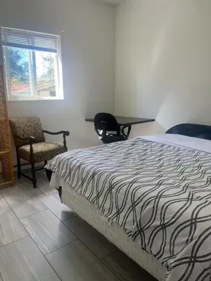 a bedroom with a bed and a chair and a table at one private room in Victoria