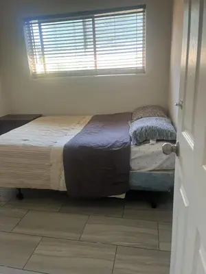 a bedroom with a bed in a room with a window at one private room in Victoria