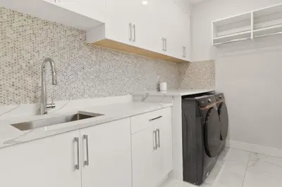 a white kitchen with a sink and a dishwasher at Spacious 6BR Entire Home Sleeps 14 Private Parking Pet-Friendly Near Vancouver in Surrey