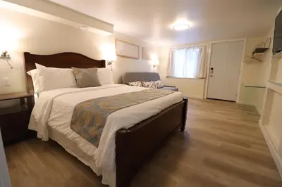 a bedroom with a large bed with a wooden floor at Victoria Gorge Waterway Vacation Home in Victoria