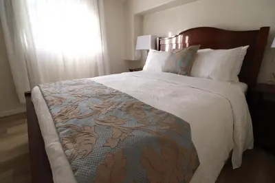 a bedroom with a large bed with a comforter at Victoria Gorge Waterway Vacation Home in Victoria