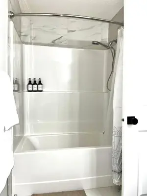 a white bath tub in a bathroom with a shower at Affordable Cozy Bedroom Close to YYC Airport in Calgary