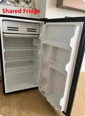 an empty refrigerator with its door open in a kitchen at Affordable Cozy Bedroom Close to YYC Airport in Calgary
