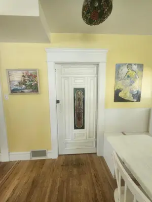 a room with a white door and paintings on the wall at Lakeview Suite by Trout Lake in Vancouver