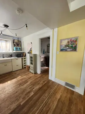 an empty kitchen with a wooden floor and yellow wall at Lakeview Suite by Trout Lake in Vancouver