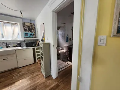 a kitchen with a sink and a refrigerator in a room at Lakeview Suite by Trout Lake in Vancouver