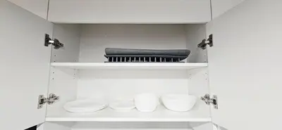 a white cabinet with three bowls and a towel at 1 BR suite near WEM, with fast WiFi and Equipped kitchen in Edmonton
