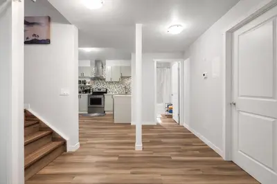 an open hallway with white walls and wood floors at Bright 2BR Suite Near YYC & Mall in Calgary
