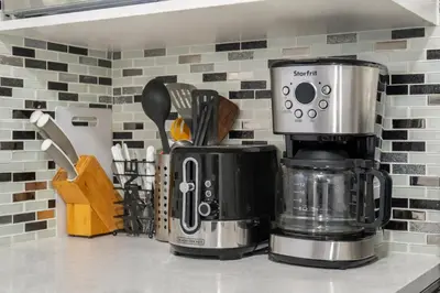 a coffee maker sitting on top of a counter at Bright 2BR Suite Near YYC & Mall in Calgary