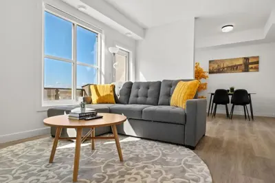 a living room with a gray couch and a table at Two Bedroom Townhouse with AC Garage Parking and Wifi in Calgary