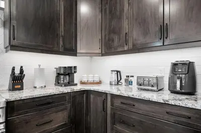 a kitchen with wooden cabinets and a counter top at Large Luxury Home Featuring Entertain Room with Karaoke Air Hockey and Pool Table in Calgary